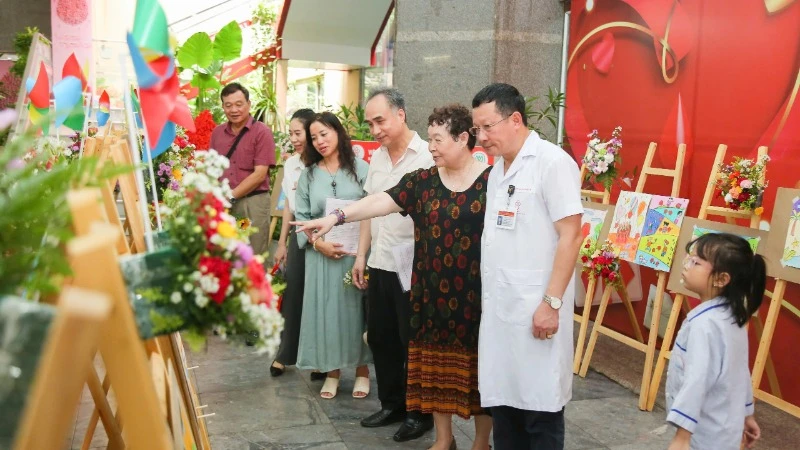 Các đại biểu tham quan triển lãm tranh vẽ của các bạn nhỏ mắc bệnh thalassemia.