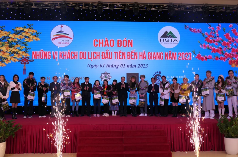 Lãnh đạo tỉnh Hà Giang tặng hoa và quà chúc mừng những vị khách đầu tiên.