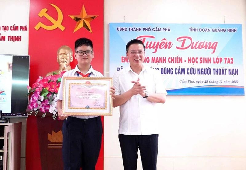 Ủy viên Ban Thường vụ Thành ủy, Phó Chủ tịch Thường trực UBND TP Cẩm Phả Đinh Ngọc Chiến trao khen thưởng cho em Hoàng Mạnh Chiến. (Nguồn: campha.gov.vn)