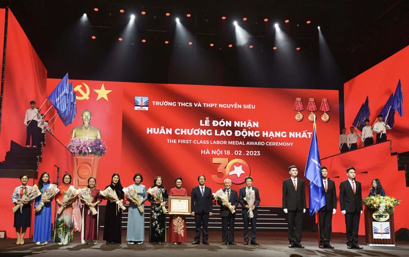 Thừa ủy quyền của Chủ tịch nước, Bộ trưởng Giáo dục và Đào tạo Nguyễn Kim Sơn trao Huân chương Lao động hạng Nhất cho Trường THCS và THPT Nguyễn Siêu. (Ảnh: THẾ ĐẠI)