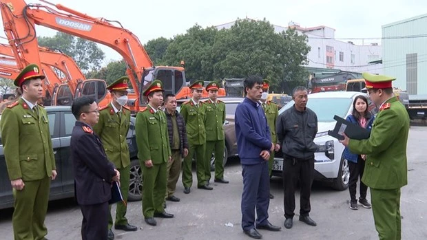 Cơ quan Công an đọc lệnh khám xét Trung tâm Đăng kiểm xe cơ giới 29-07D. (Nguồn: Hà Nội mới).