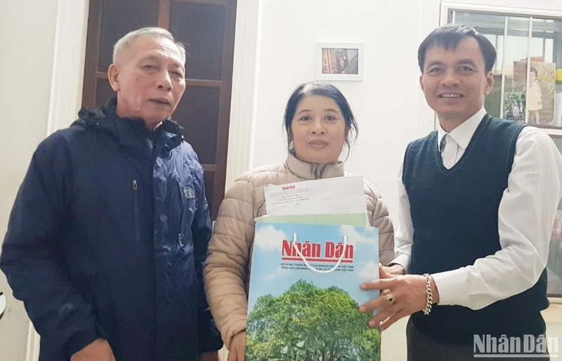 Bí thư Chi bộ Khu phố 5, phường 5, thành phố Đông Hà (bên trái) tặng các ấn phẩm Báo Nhân Dân cho bạn đọc nhân dịp Tết Quý Mão 2023.
