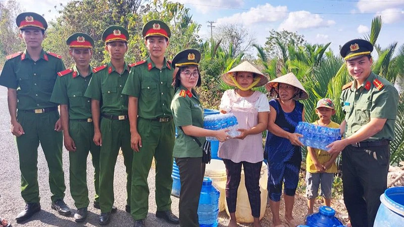 Công an Sóc Trăng tặng nước uống đóng chai cho người dân.