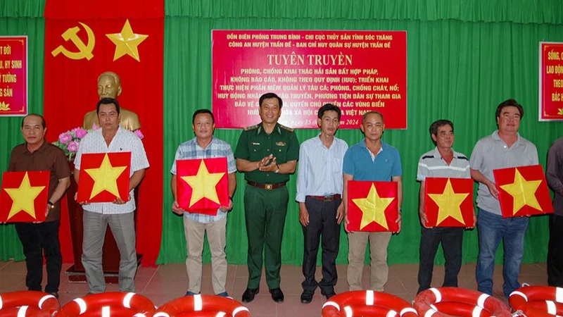 Tặng cờ Tổ quốc và phao cứu sinh cho ngư dân.