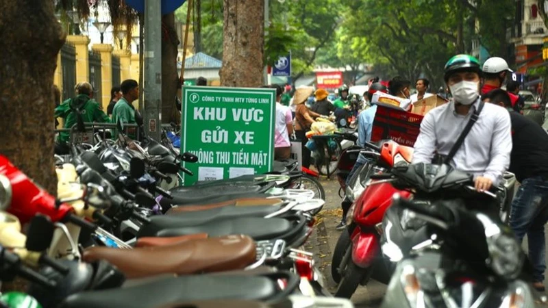 Điểm trông giữ xe máy hạn chế dùng tiền mặt trên phố Phủ Doãn.