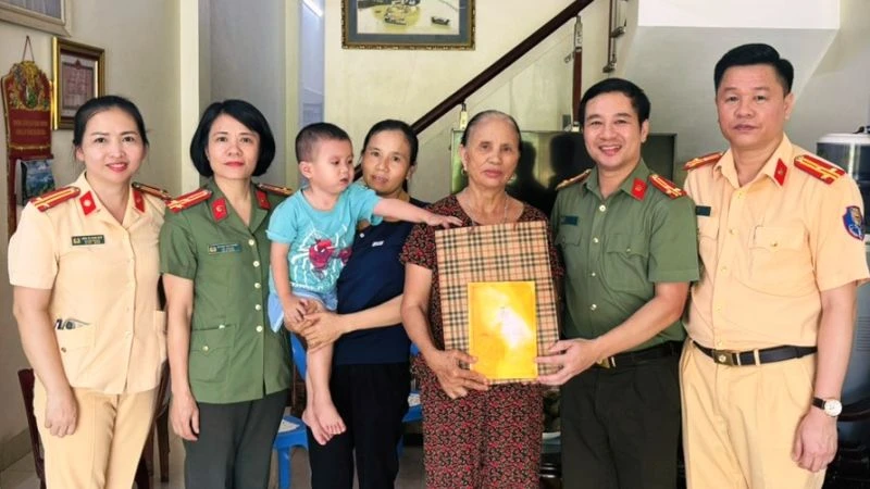 Đại diện đoàn công tác trao tặng quà cho trẻ em cùng gia đình.