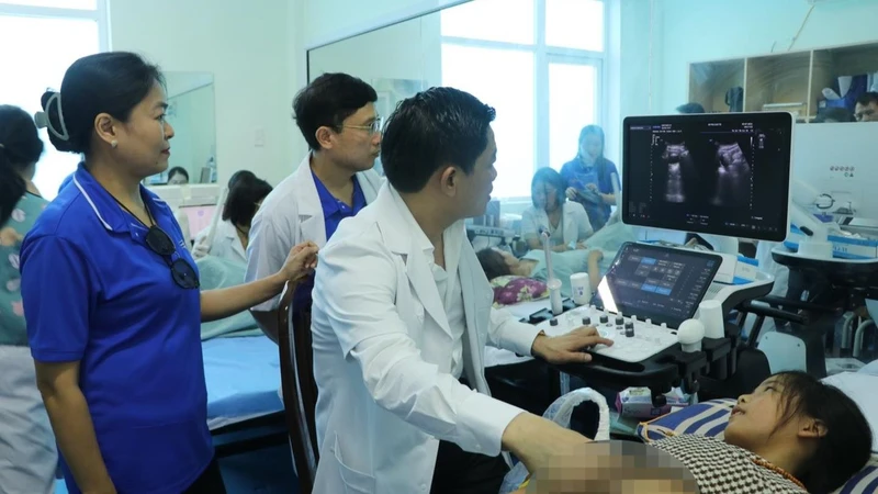 Thầy thuốc nhân dân, Giáo sư, Tiến sĩ Nguyễn Duy Ánh, Giám đốc Bệnh viện Phụ sản Trung ương khám cho trẻ em tại huyện Vĩnh Linh, tỉnh Quảng Trị.