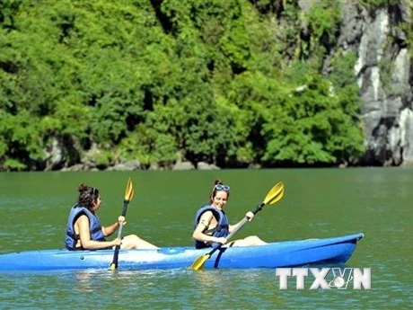 Du khách trải nghiệm chèo thuyền kayak, thuyền tay trên Vịnh Hạ Long. (Ảnh: Thanh Vân/TTXVN)