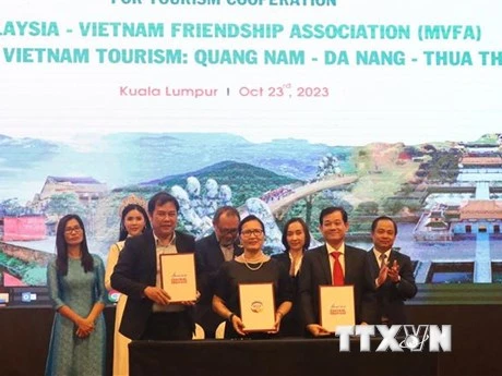 Đại diện Trung tâm Xúc tiến du lịch 3 tỉnh thành Quảng Nam-Đà Nẵng-Thừa Thiên Huế và Chủ tịch Hội Hữu nghị Malaysia–Việt Nam (giữa) ký kết biên bản ghi nhớ hợp tác truyền thông và quảng bá du lịch. (Ảnh: TTXVN)