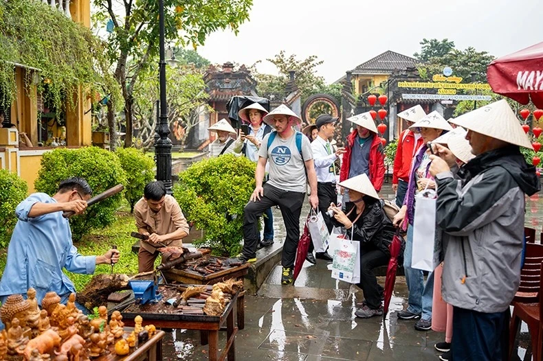 Khách quốc tế tham quan, tìm hiểu quy trình sản xuất các mặt hàng thủ công mỹ nghệ tại thành phố Hội An hôm 1/1. (Ảnh: TẤN NGUYÊN) 