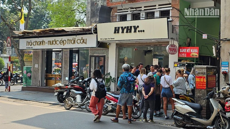 Khách du lịch nước ngoài đứng xếp hàng chờ mua bánh mì tại một cửa hàng nhỏ trên phố Lý Quốc Sư, Hà Nội. (Ảnh: T.LINH)