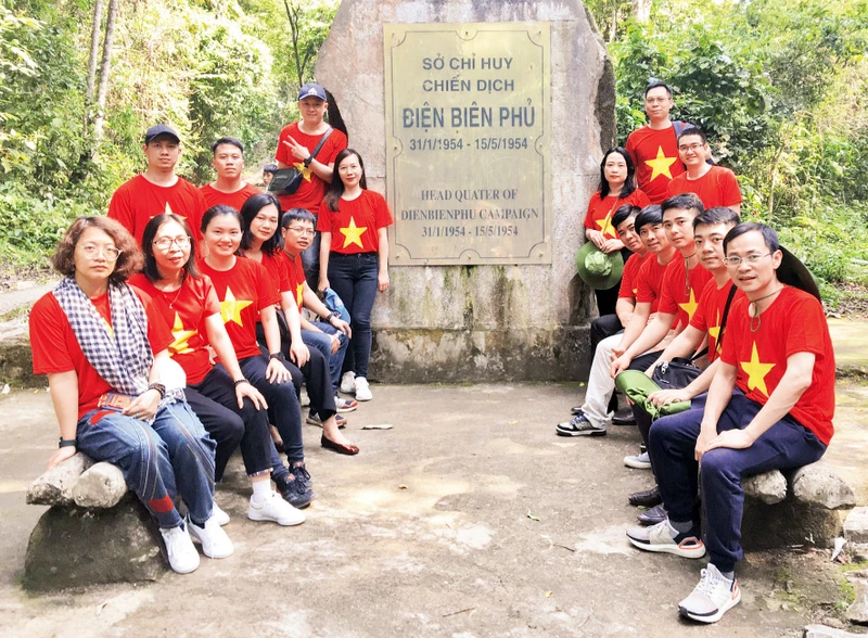 Du khách chụp ảnh tại bia Di tích Sở Chỉ huy Chiến dịch Điện Biên Phủ tại Mường Phăng (Điện Biên). Ảnh: LINH HỒNG