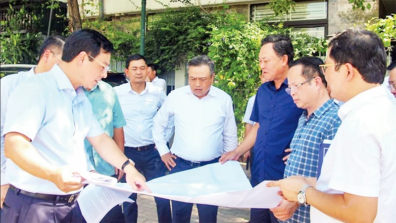 Chủ tịch UBND thành phố Hà Nội Trần Sỹ Thanh (đứng giữa) kiểm tra thực tế tại ô đất xây dựng trường học thuộc khu chức năng đô thị Ao Sào, Thịnh Liệt, quận Hoàng Mai. (Ảnh THỦY TIÊN)