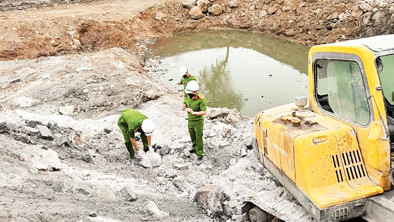 Các lực lượng chức năng lấy mẫu trong khuôn viên khu vực xử lý chất thải của Công ty cổ phần Môi trường Thiên Thanh. (Ảnh Công an cung cấp)