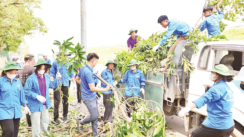 Thanh niên quận Hoàng Mai thu gom rác thải khắc phục hậu quả bão số 3.