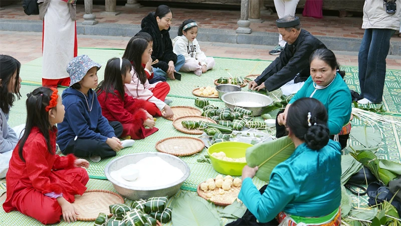 Các em nhỏ được trải nghiệm gói bánh chưng tại Bảo tàng Dân tộc học Việt Nam.