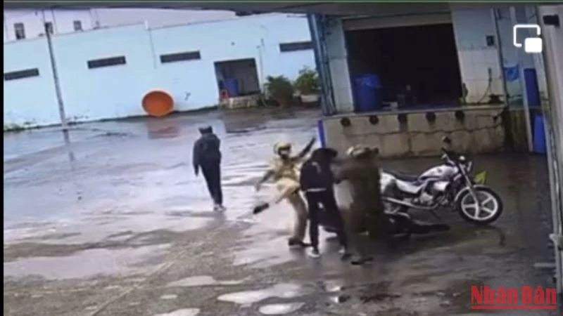 Các cán bộ, chiến sĩ Công an đánh tới tấp nam sinh điều khiển xe máy. (Ảnh cắt từ clip)