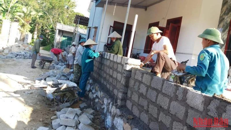 Cán bộ, đảng viên xã Sơn Châu giúp các hộ dân xây dựng lại tường rào sau khi hiến đất mở rộng đường.
