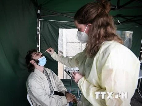 Nhân viên y tế lấy mẫu xét nghiệm Covid-19 cho người dân tại Paris, Pháp. (Ảnh: AFP/TTXVN)