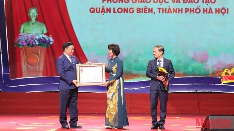 Đồng chí Đinh Tiến Dũng trao Huân chương Lao động hạng Nhất cho Phòng Giáo dục và Đào tạo quận Long Biên. (Ảnh: THANH TÙNG) 