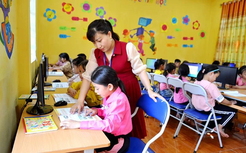 Do thiếu giáo viên, cô Trần Thị Thu Huyền, giáo viên môn Tin học, Trường tiểu học Mường Vi phải dạy cho cả học sinh Trường trung học cơ sở Mường Vi (huyện Bát Xát, tỉnh Lào Cai). (Ảnh QUỐC HỒNG)