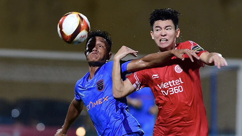 Pha tranh bóng giữa cầu thủ hai đội Viettel FC (áo đỏ) và Becamex Bình Dương. (Ảnh THANH HẢI)
