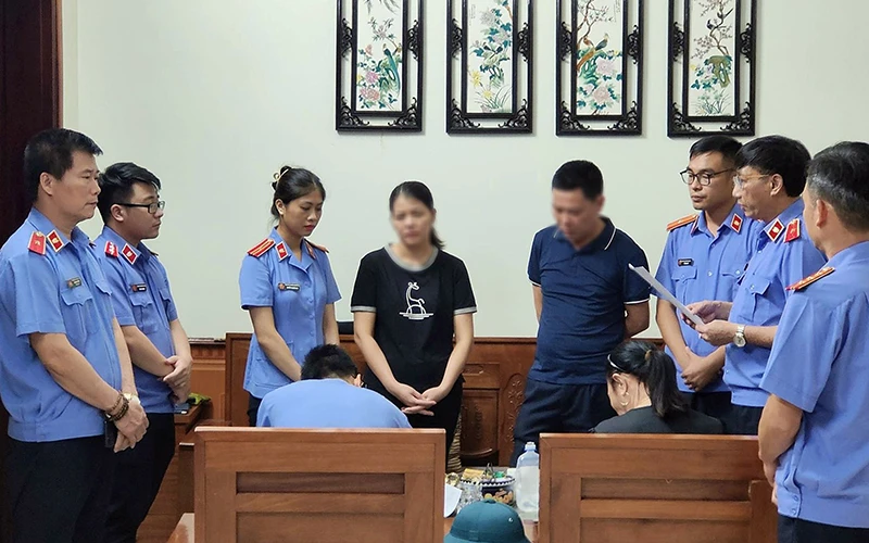 Cơ quan điều tra Viện Kiểm sát nhân dân tối cao thi hành lệnh bắt bị can, tạm giam đối với bà Trần Thị Hoa (thứ 4 từ trái sang), chấp hành viên thuộc Chi cục Thi hành án dân sự thành phố Yên Bái. (Ảnh Văn Thành)