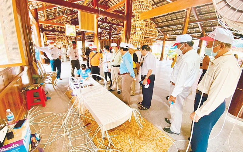 Du khách xem một công đoạn thêu truyền thống.