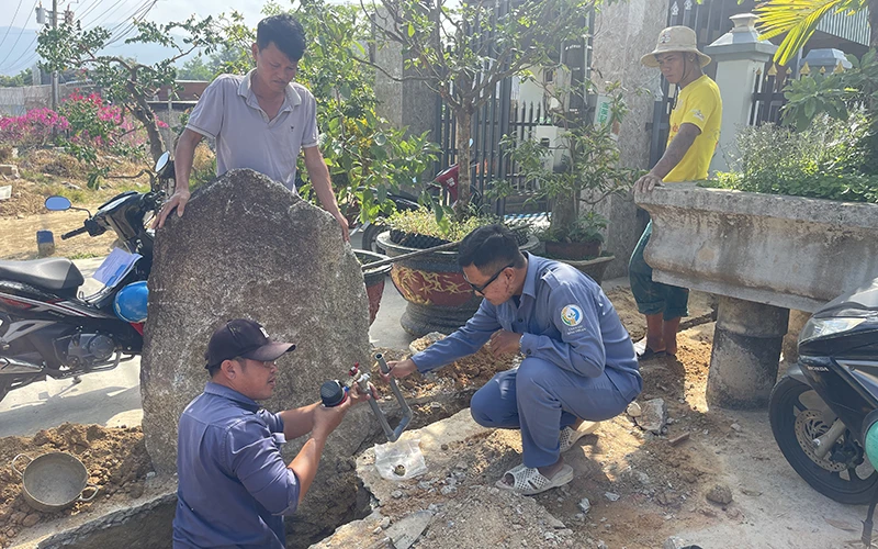 Nhân viên Nhà máy nước La Dạ lắp đường ống dẫn nước sạch cho người dân.