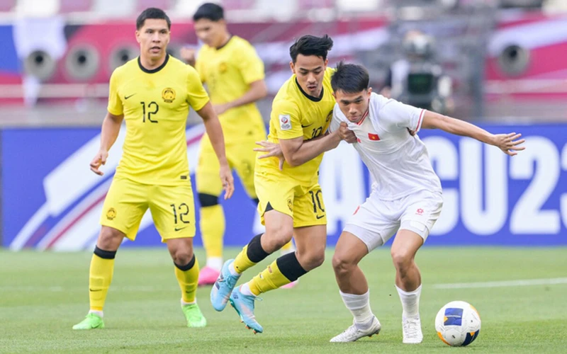 U23 Việt Nam (áo trắng) vào tứ kết sau chiến thắng 2-0 trước U23 Malaysia (Ảnh AFC)