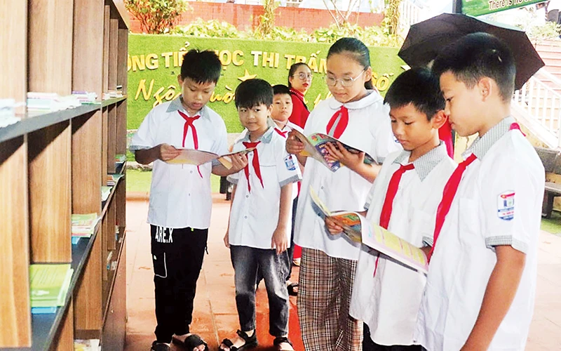 Học sinh Trường tiểu học thị trấn Vôi số 1 (Lạng Giang) đọc sách tại tủ sách nhà trường. (Ảnh Minh Thu)