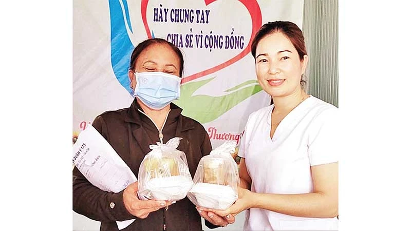 Dược sĩ Lê Thị Thanh Tâm, thành viên “Bếp ăn nhân ái” trao các phần cơm, tặng bệnh nhân đang khám, điều trị tại Trung tâm Y tế huyện Bù Đốp.