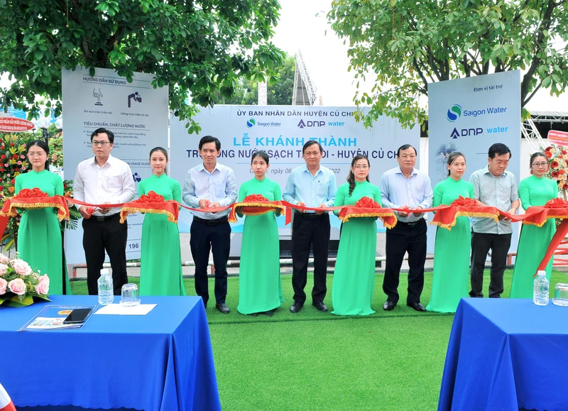 Đại diện ban lãnh đạo huyện Củ Chi và các nhà tài trợ cùng cắt băng khánh thành trụ nước uống sạch cộng đồng.