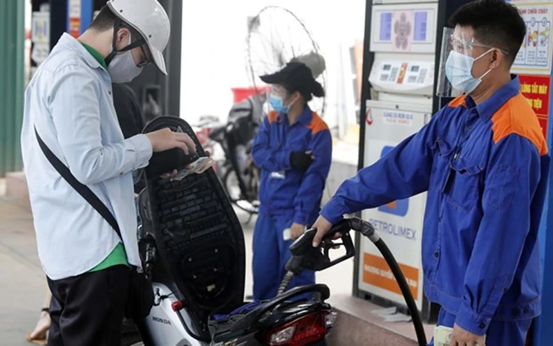Nhân viên Petrolimex đang bán xăng cho khách hàng. (Ảnh: Thành Đạt)