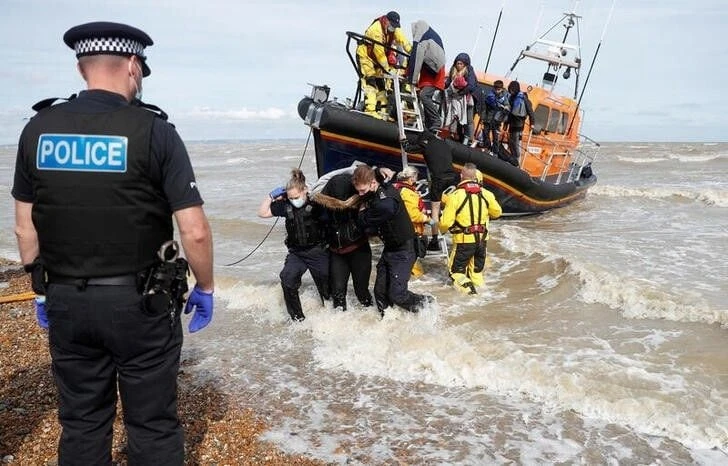 Một chiếc thuyền RNLI chở những người di cư trên tàu gặp các Sĩ quan Lực lượng Biên phòng và Cảnh sát tại bến cảng ở Dungeness, Anh, ngày 13/9/2021. Ảnh: REUTERS