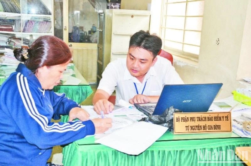 Học tập và làm theo phong cách Hồ Chí Minh, cán bộ phường 9, quận 11 tận tình hướng dẫn người dân thủ tục mua bảo hiểm y tế tự nguyện hộ gia đình.
