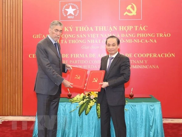 Ông Lê Hoài Trung, Ủy viên Trung ương Đảng, Trưởng Ban Đối ngoại Trung ương và ông Miguel Mejia, Tổng Bí thư Đảng Phong trào cánh tả thống nhất Dominica trao bản thỏa thuận hợp tác giữa hai Đảng. (Ảnh: TTXVN)