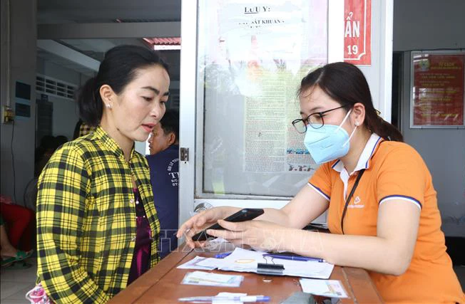 Thành viên Tổ công nghệ số cộng đồng tỉnh Sóc Trăng giúp người dân cài đặt ứng dụng VNeID. (Ảnh: TUẤN PHI)