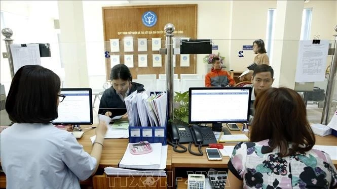 Giải quyết thủ tục hành chính tại bảo hiểm xã hội địa phương. (Ảnh: TTXVN)