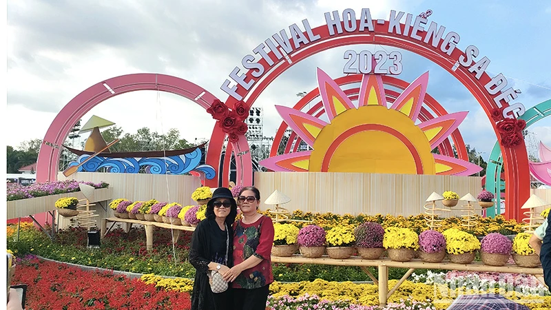 Du khách chụp ảnh lưu niệm tại một cụm tiểu cảnh tại Festival Hoa-kiểng Sa Đéc. (Ảnh: HỮU NGHĨA)