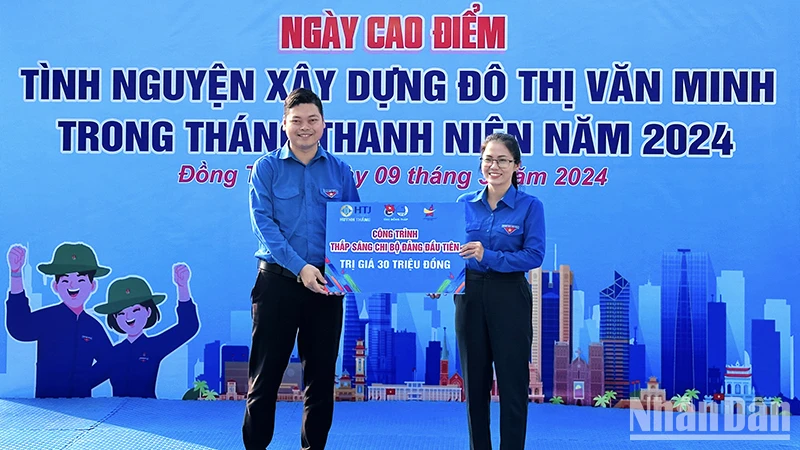 Phó Bí thư Tỉnh đoàn Đồng Tháp Lê Hoàng Quyết (bên trái) trao bảng tượng trưng tặng công trình “Thắp sáng Chi bộ Đảng đầu tiên” cho đại diện Thành đoàn Cao Lãnh.