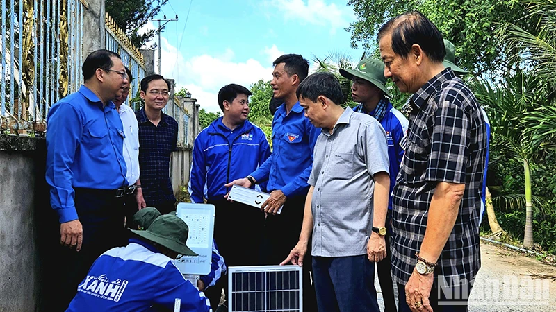 Các chiến sĩ tình nguyện thực hiện lắp trụ đèn chiếu sáng của công trình “Thắp sáng đường quê”.
