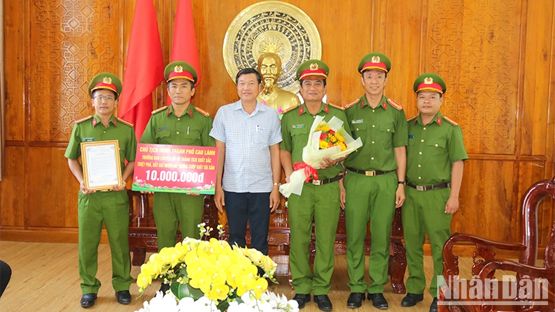 Chủ tịch Ủy ban nhân dân thành phố Cao Lãnh Võ Phan Thành Minh trao thưởng cho Ban chuyên án. (Ảnh: PHƯỚC THANH)