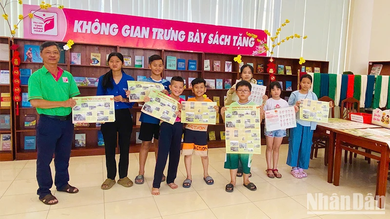 Ông Trần Tuấn Khanh, Phó Trưởng phòng Công tác người đọc, Thư viện tỉnh Đồng Tháp, tặng phụ trương đến bạn đọc trẻ. (Ảnh: Thư viện tỉnh Đồng Tháp)