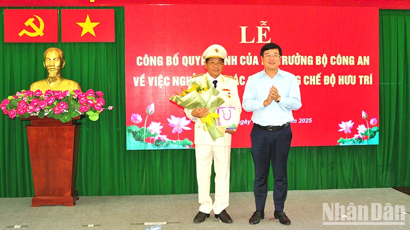 Ủy viên Trung ương Đảng, Bí thư Tỉnh ủy Đồng Tháp Lê Quốc Phong trao Huy hiệu 40 năm tuổi Đảng và tặng hoa chúc mừng Đại tá Nguyễn Văn Hiểu. (Ảnh: Công an cung cấp)