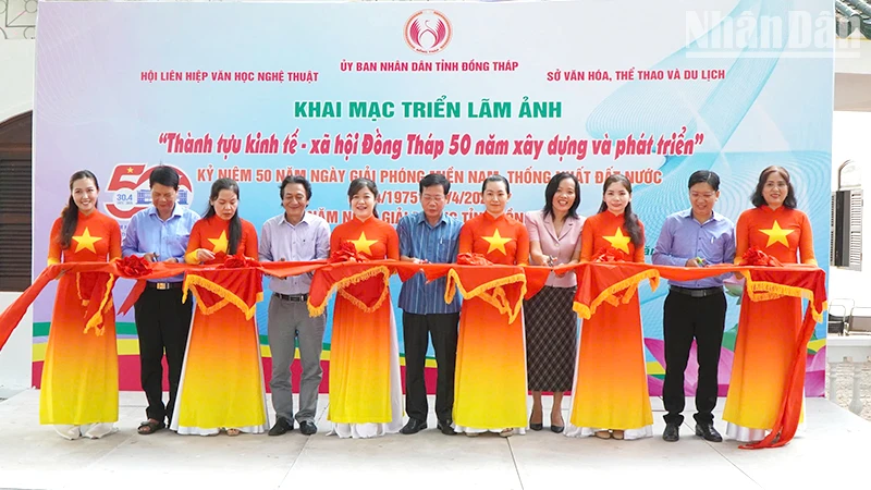 Nghi thức cắt băng khai mạc triển lãm ảnh. (Ảnh: NHƯ ANH)