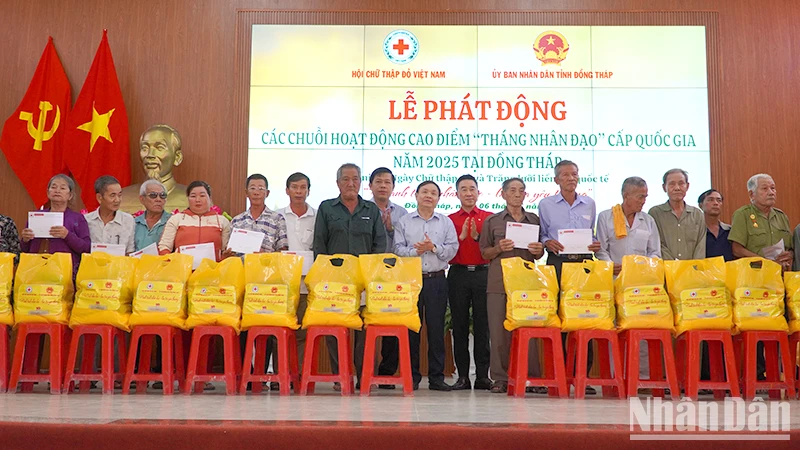 Đại diện 20 hộ gia đình chính sách có hoàn cảnh khó khăn ở huyện Tân Hồng nhận quà với mỗi suất 2 triệu đồng tiền mặt. (Ảnh: HỮU NGHĨA)