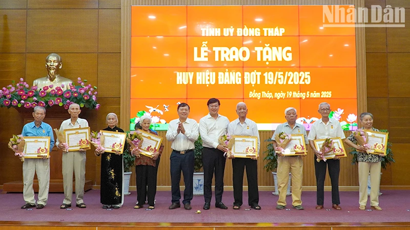 Lãnh đạo tỉnh Đồng Tháp trao Huy hiệu 60 và 65 năm tuổi Đảng cho các đảng viên. (Ảnh: HỮU NGHĨA)