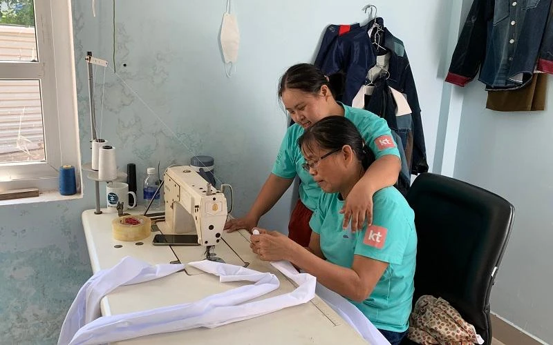 Cô Thanh (ngồi) tỉ mỉ hướng dẫn Linh gấp nếp vải.