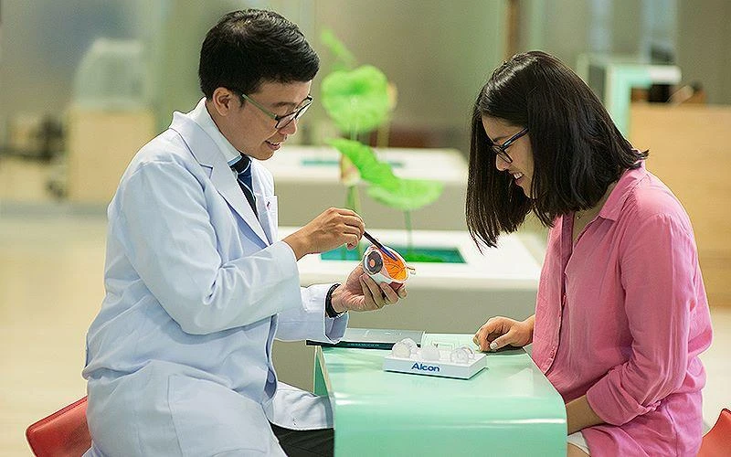 TS, BS Trần Đình Minh Huy (bên trái) chăm sóc, giải đáp thắc mắc của người bệnh. 